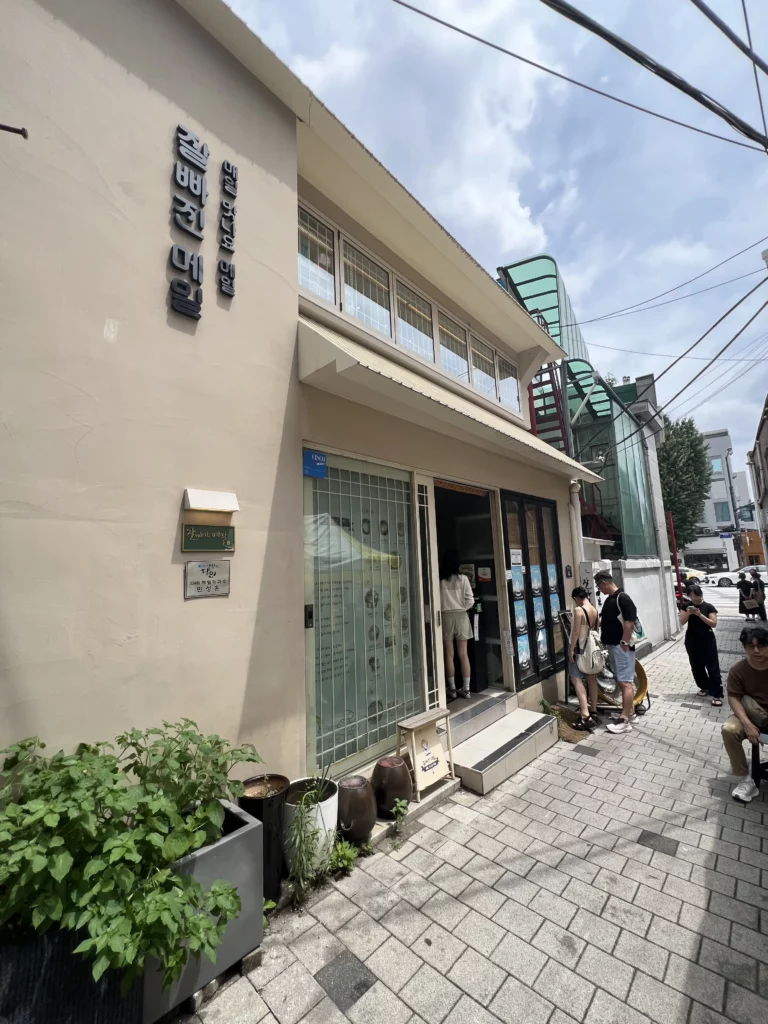 Jalppaejin Memil restaurant exterior with customers waiting outside popular Korean buckwheat noodle makguksu specialty restaurant in Seoul traditional neighborhood.