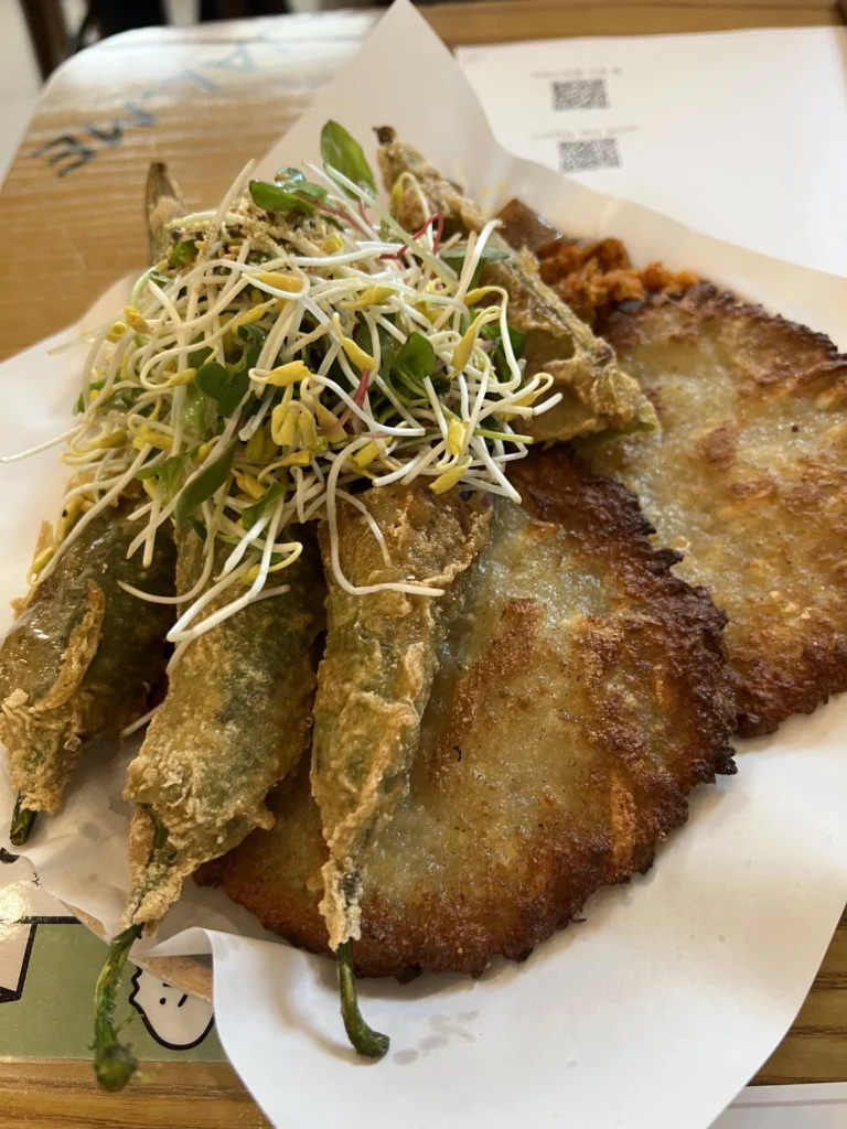 Korean memil jeonbyeong buckwheat crepes and fried peppers topped with fresh bean sprouts served at Jalppaejin Memil traditional restaurant Seoul.