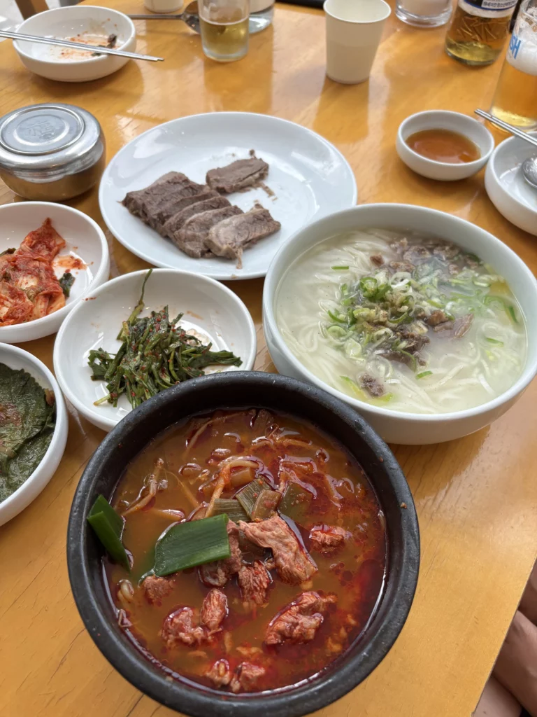 Complete traditional Korean meal at Sohojeong restaurant featuring Andong guksi noodles, hanwoo suyuk boiled beef, kimchi stew, and banchan side dishes representing presidential legacy cuisine in Seoul.
