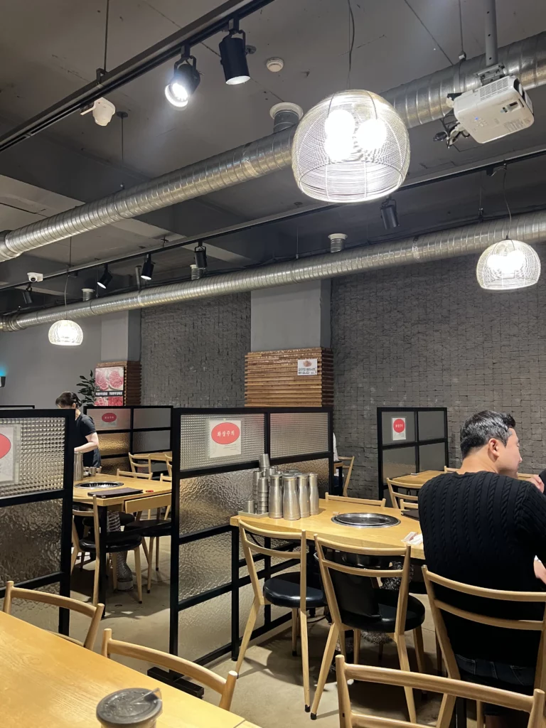 Modern interior dining room with built-in charcoal grills at Mapo Charcoal Pork Ribs, an authentic Korean BBQ restaurant in Gangnam, Seoul.