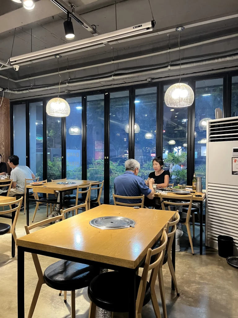 Spacious dining area with window seating and built-in grill tables at Mapo Charcoal Pork Ribs Korean BBQ restaurant in Nonhyeon-dong, Gangnam.