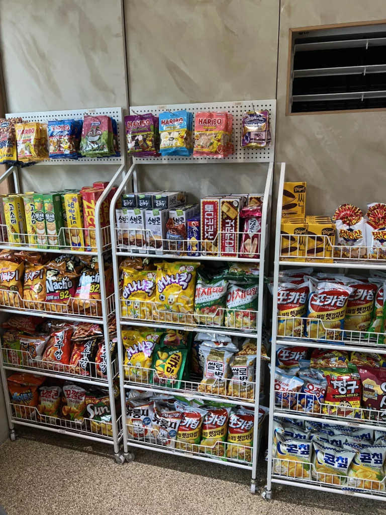 Snack display shelves at Bukhansan Lounge featuring Korean chips, HARIBO gummy bears, and packaged treats available for purchase at the Bukhansan National Park mountain view cafe in Seoul.