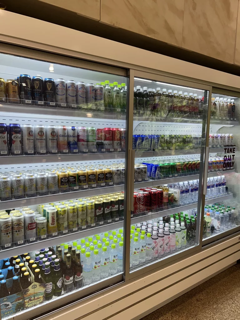 Refrigerated beverage display at Bukhansan Lounge cafe featuring Korean drinks, bottled teas, coffee beverages, and refreshments for post-hike refreshment at Bukhansan National Park mountain view cafe in Seoul.