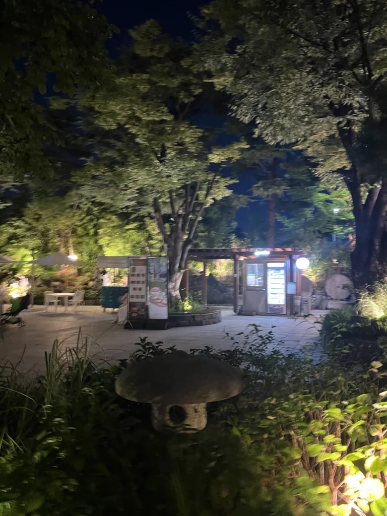 Traditional stone lantern and Korean garden landscape illuminated at night at Samwon Garden Seoul featuring serene hanok-style architecture for premium Hanwoo galbi dining.