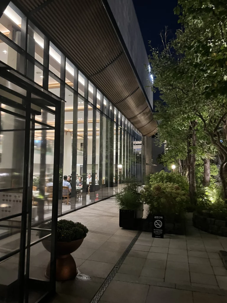 Modern exterior entrance of Samwon Garden Seoul at night showcasing contemporary architecture and landscaped garden at Michelin Guide-featured Hanwoo galbi restaurant in Gangnam.