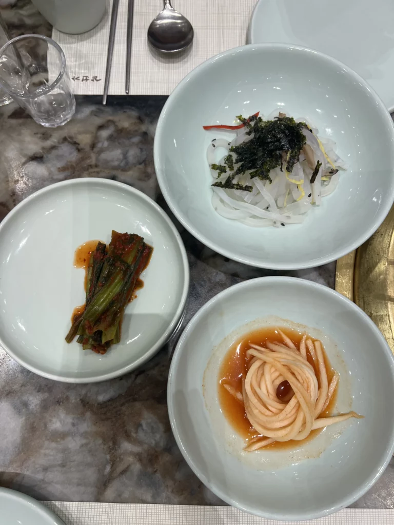Traditional Korean banchan side dishes including kimchi and pickled vegetables served at Samwon Garden Seoul with premium Hanwoo galbi Korean BBQ.