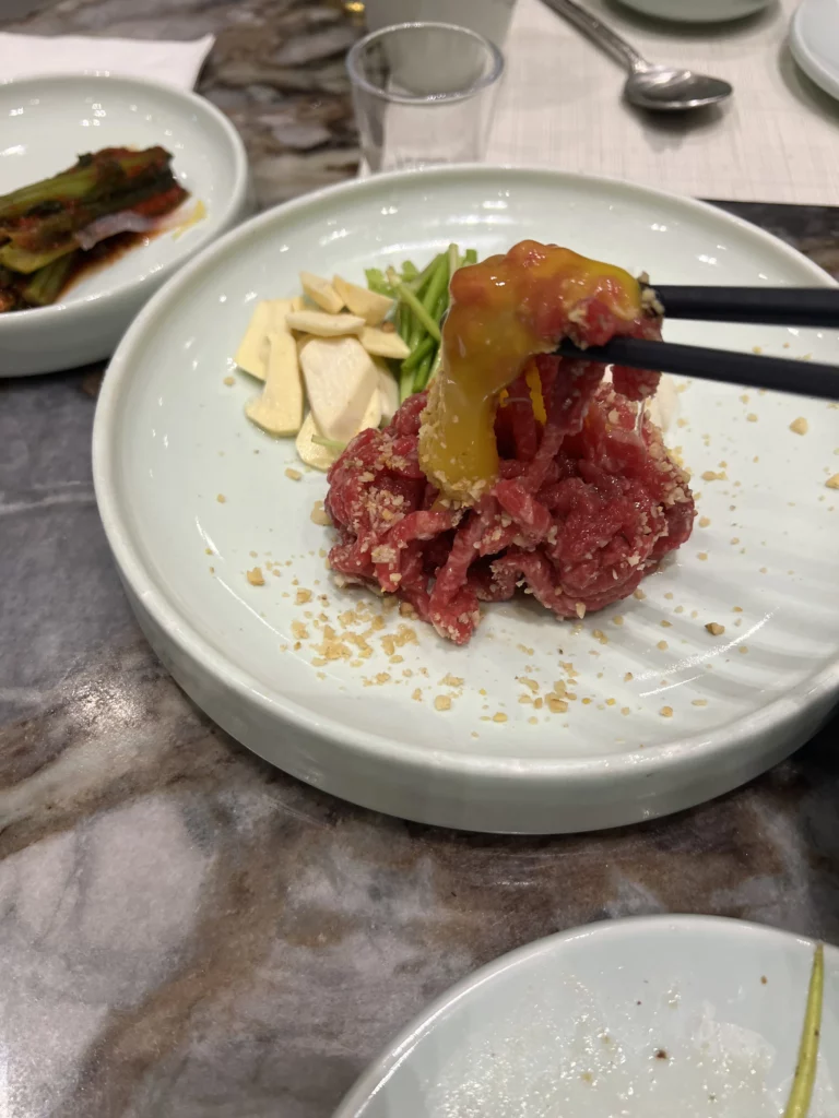 Premium Hanwoo beef tartare with raw egg yolk and pine nuts served with julienned vegetables at Samwon Garden Korean BBQ restaurant in Seoul.