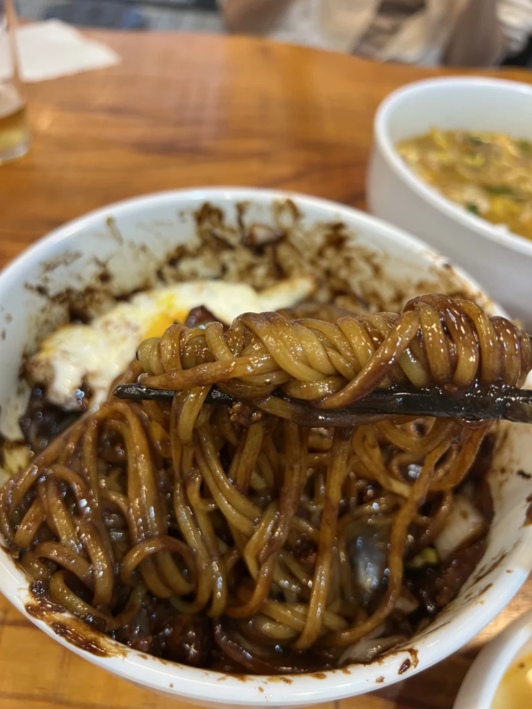 Authentic jajangmyeon black bean noodles topped with fried egg at Junghwa Baekban, a Seoul restaurant specializing in Korean-Chinese cuisine.