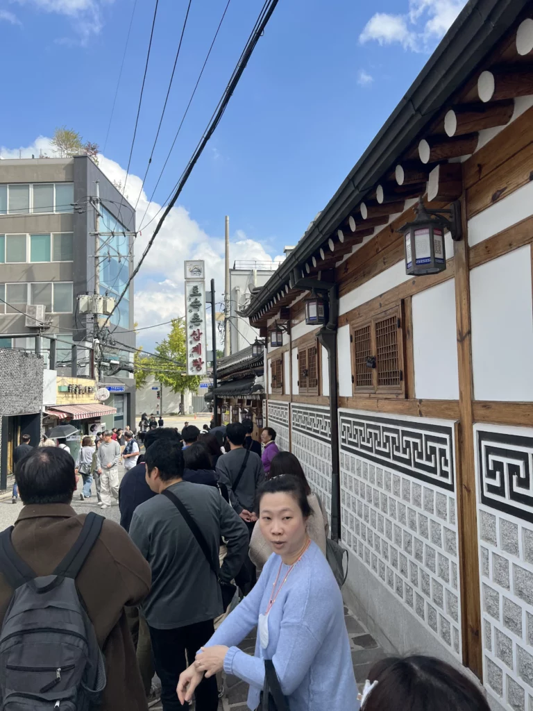 Visitors queuing outside Tosokchon Samgyetang traditional hanok restaurant with Korean architectural details near Gyeongbokgung Palace Seoul, famous destination for authentic Korean ginseng chicken soup samgyetang.