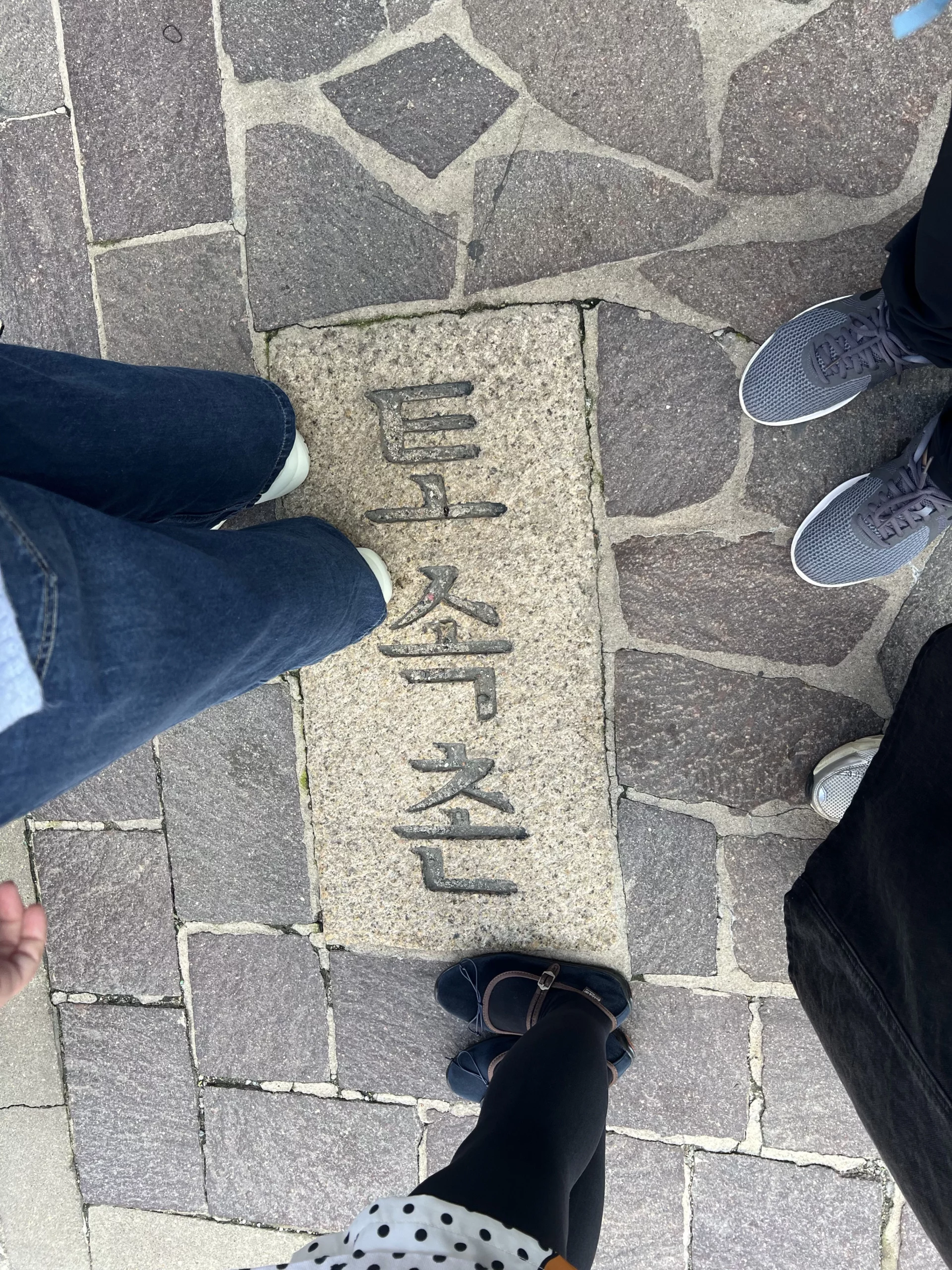Stone pavement marker with Tosokchon Samgyetang Korean characters engraved, directional signage near Seoul's legendary Korean ginseng chicken soup restaurant in Jongno-gu near Gyeongbokgung Palace.