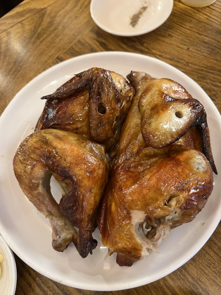 Tosokchon rotisserie chicken jingugui tongdak with golden crispy skin served at Seoul's legendary Korean samgyetang restaurant near Gyeongbokgung Palace.