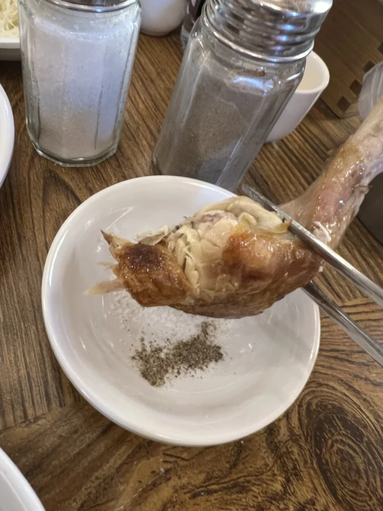 Tender chicken piece from Tosokchon samgyetang seasoned with salt and pepper, proper eating method for Korean ginseng chicken soup in Seoul.