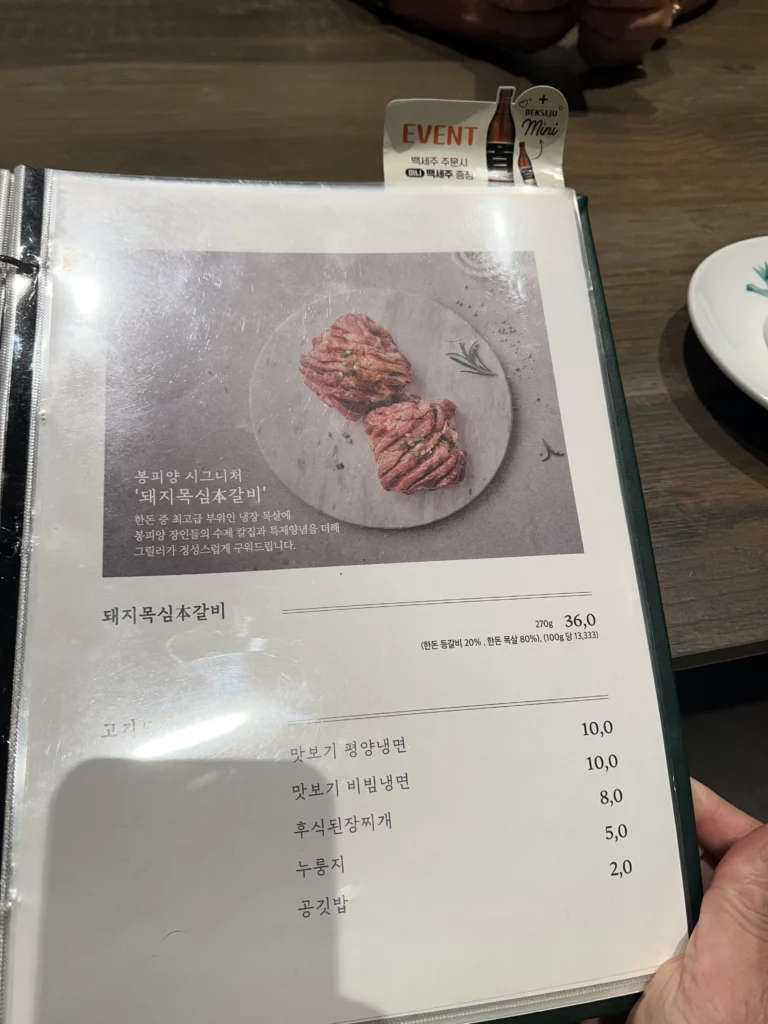 Bongpiyang menu page showing dwaeji galbi pork ribs and Pyongyang-style naengmyeon cold noodles at Michelin Bib Gourmand Korean BBQ restaurant.