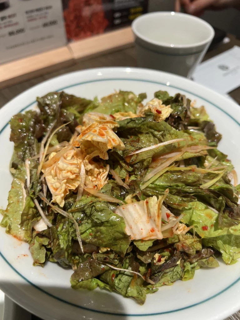 Fresh lettuce and kimchi salad banchan served as traditional Korean BBQ accompaniment at Bongpiyang pork galbi restaurant.