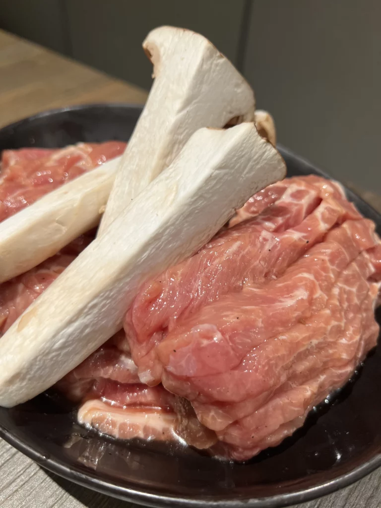 Fresh premium pork ribs with bone ready for charcoal grilling at Bongpiyang, Seoul's Michelin Bib Gourmand Korean BBQ restaurant.