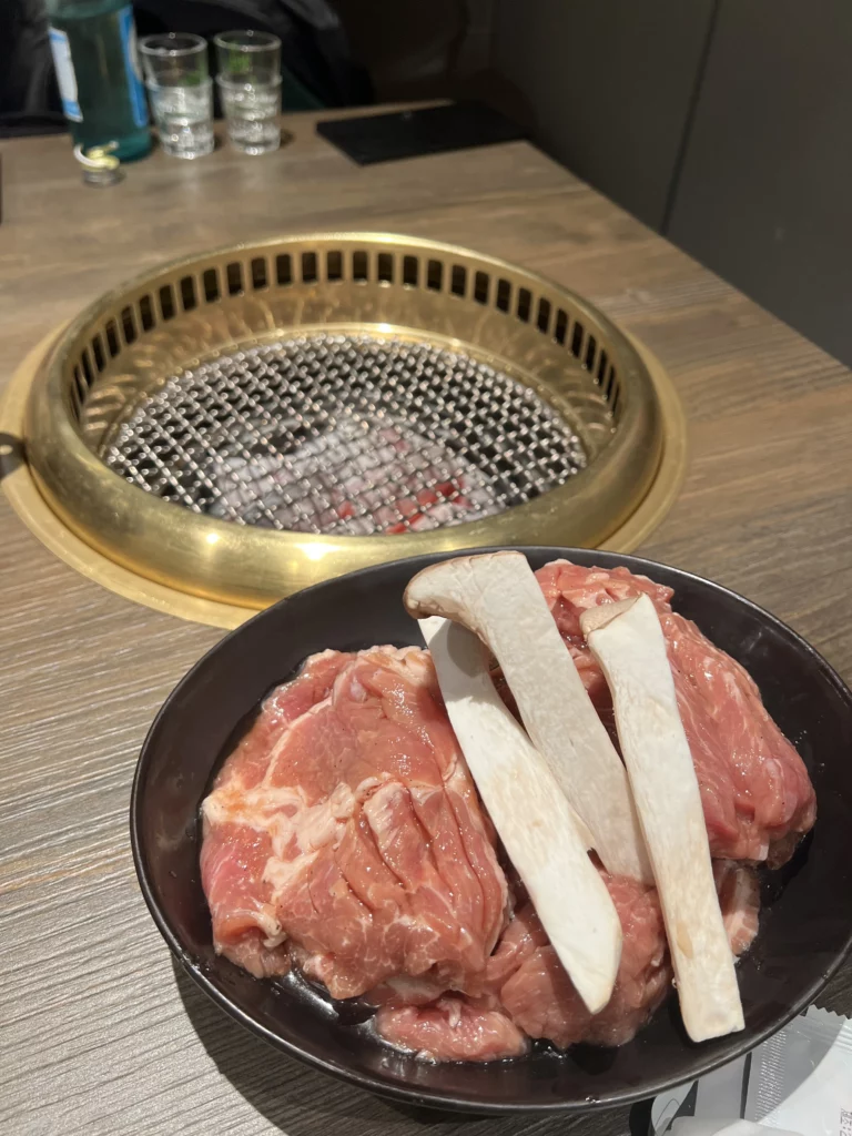 Fresh marinated pork ribs with bone ready to grill over glowing charcoal at Bongpiyang Korean BBQ restaurant in Seoul.