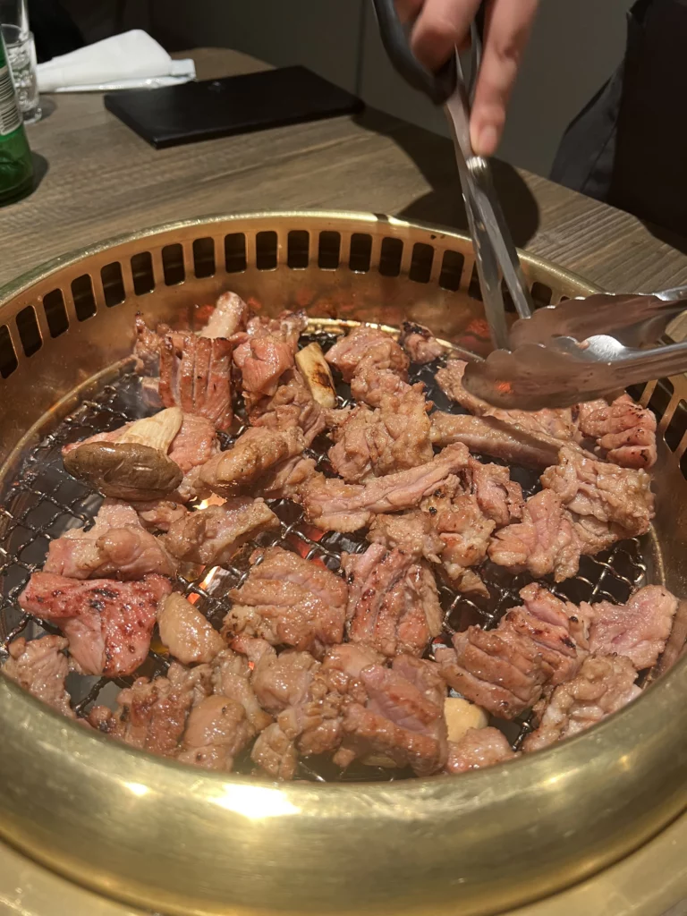 Charcoal-grilled pork ribs being cooked on a Korean BBQ grill at Bongpiyang, Seoul's Michelin Bib Gourmand restaurant in Gangnam.