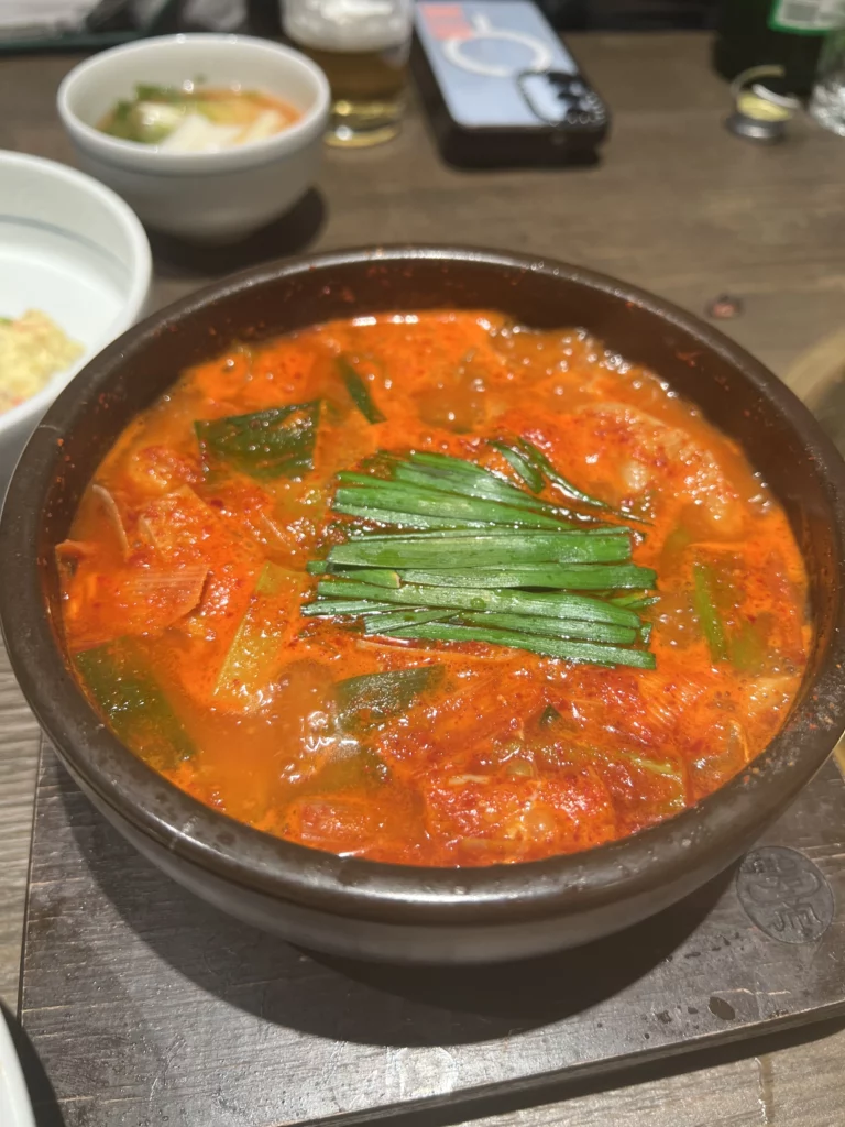 Spicy kimchi stew jjigae with scallions served at Bongpiyang Korean BBQ restaurant in Gangnam Seoul.