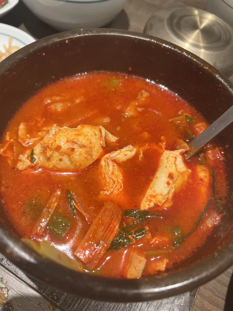 Kimchi jjigae stew with fermented cabbage in spicy broth at Bongpiyang Michelin Bib Gourmand Korean BBQ Seoul.