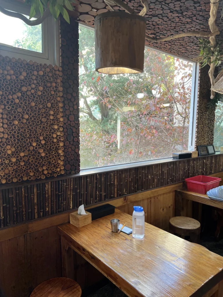 Traditional Korean dining area at Nunnamu-jip Bukchon restaurant featuring wooden tables and nature-inspired interior design in Seoul.
