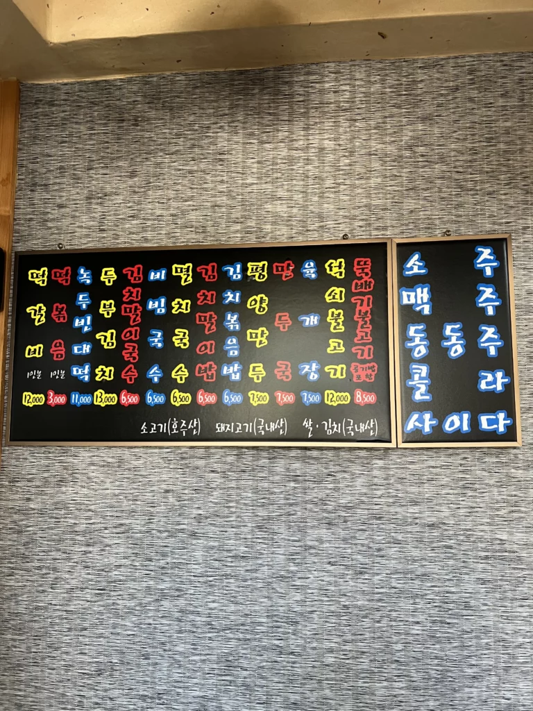 Korean menu board at Nunnamu-jip Bukchon restaurant displaying bulgogi dumpling soup and mung bean pancake dishes with prices in Seoul.