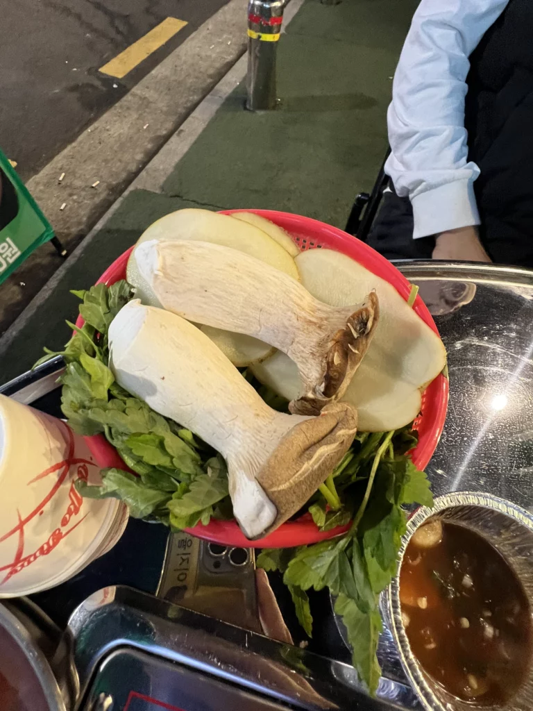 Fresh king oyster mushrooms and lettuce leaves served as accompaniments for aged samgyeopsal at Gimsukseoung Korean BBQ restaurant in Seoul.