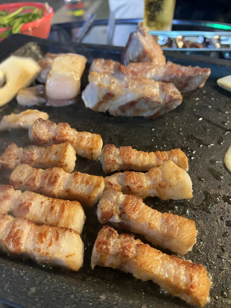 Crispy golden-brown 22-day aged samgyeopsal pieces perfectly grilled and ready to eat at Gimsukseoung Korean BBQ restaurant in Seoul.