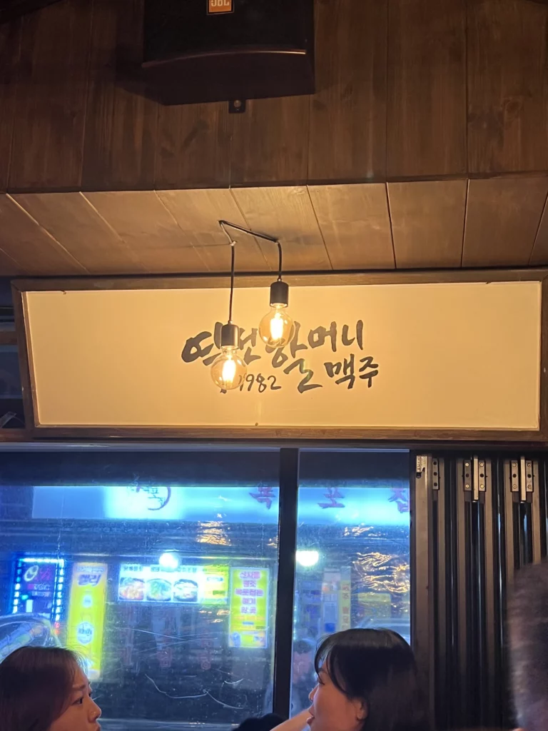Yeokjeon Halmae Maekju storefront signage with 1982 establishment year showing traditional Korean beer pub entrance at night.