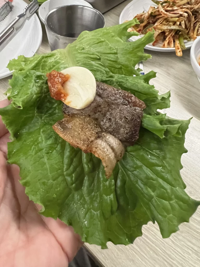 Lettuce wrap ssam with grilled samgyeopsal pork belly garlic and ssamjang sauce at Moosik authentic Korean BBQ restaurant in Sinsa-dong Gangnam Seoul.