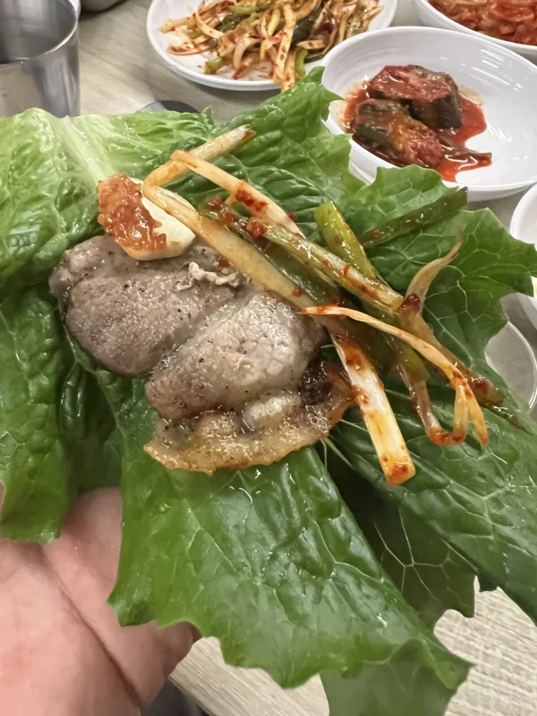 Lettuce wrap filled with grilled samgyeopsal pork belly and pa kimchi at Moosik authentic Korean BBQ restaurant in Sinsa-dong Gangnam Seoul.