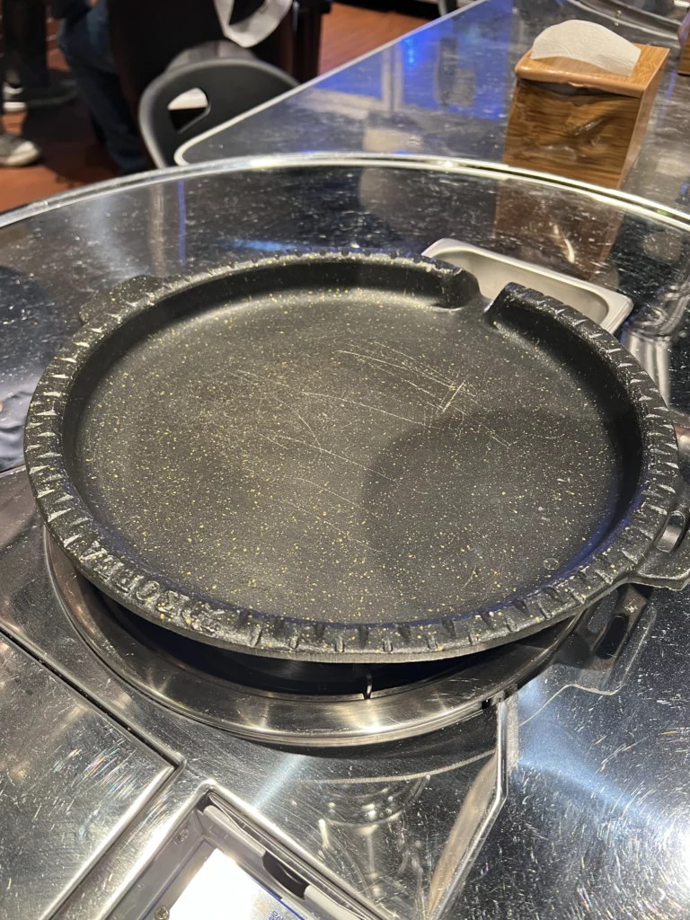 Clean non-stick grill plate ready for cooking samgyeopsal at Moosik authentic Korean BBQ restaurant in Sinsa-dong Gangnam Seoul.