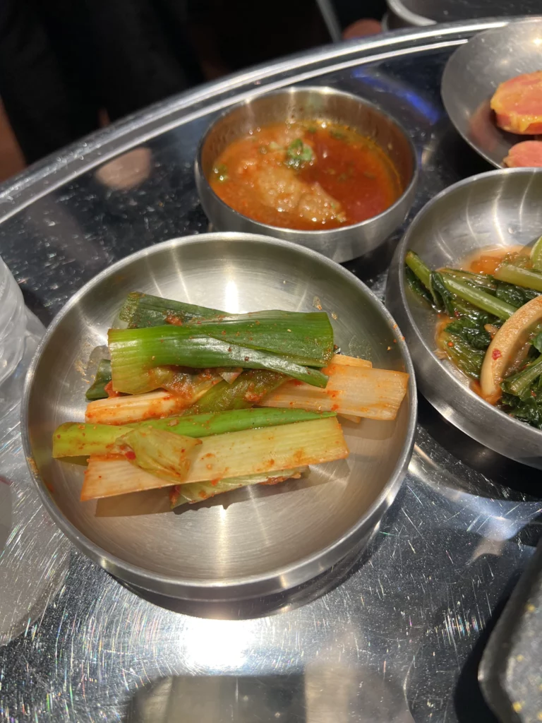 Pa kimchi green onion and assorted Korean banchan side dishes served with samgyeopsal at Moosik restaurant in Sinsa-dong Gangnam Seoul.