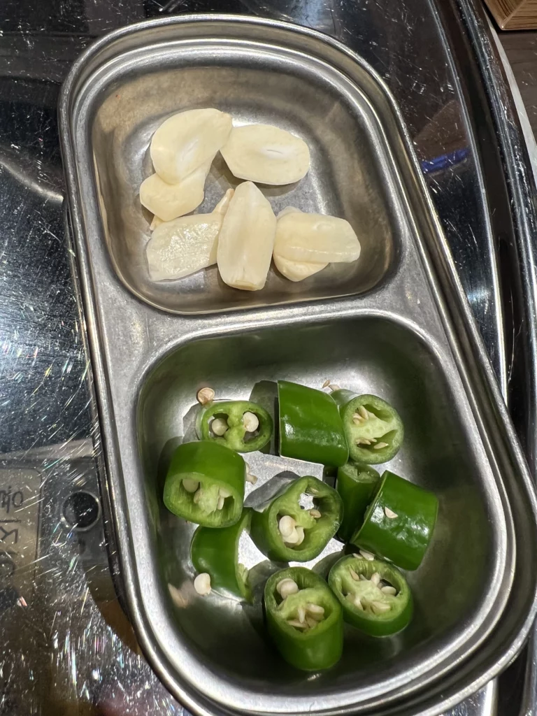 Fresh garlic cloves and sliced green peppers served as accompaniments for samgyeopsal at Moosik Korean BBQ restaurant in Sinsa-dong Gangnam Seoul.