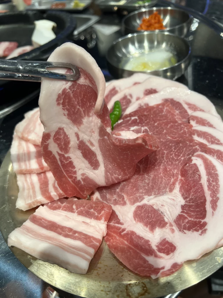 Premium marbled pork belly slices served at Moosik restaurant in Sinsa-dong Gangnam Seoul for authentic Korean samgyeopsal BBQ experience.