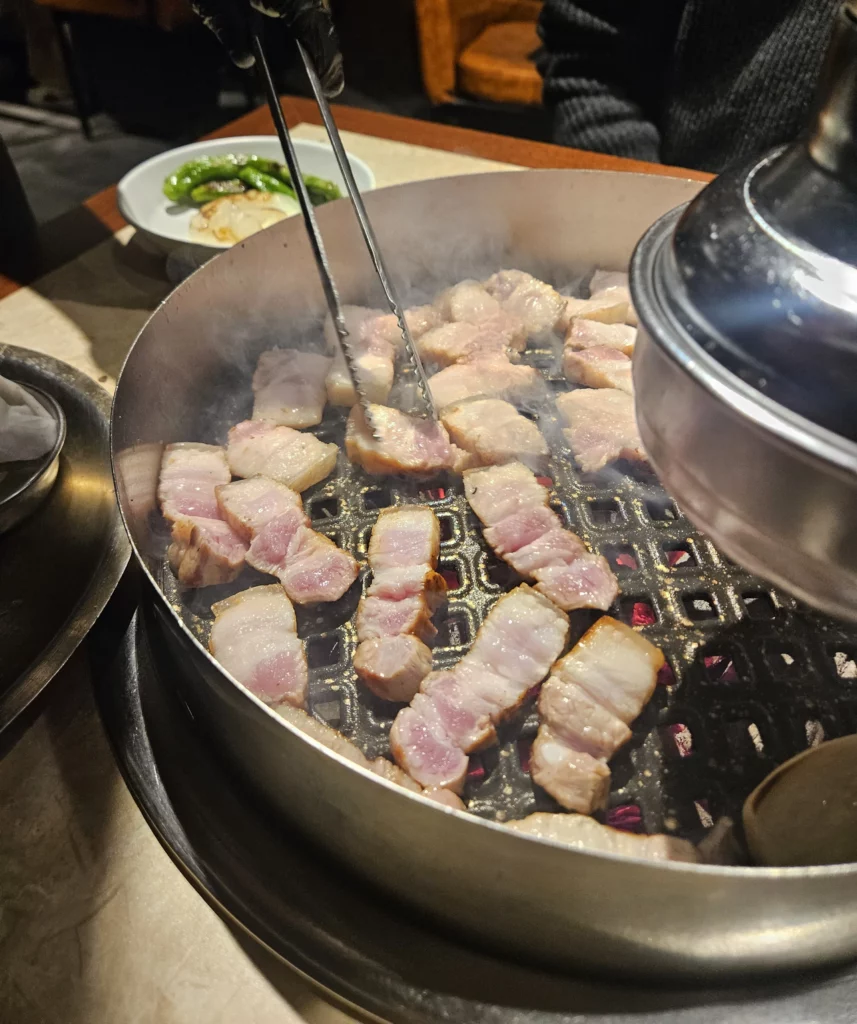 Thin cut pieces of samgyeopsal over hot grill at Keum Eun Don K-BBQ. 