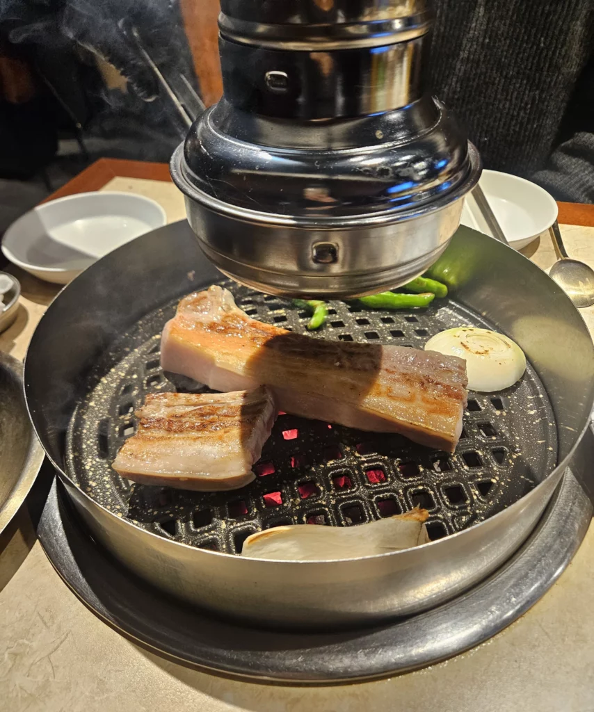 Grilled sizzling samgyeopsal with grilled onion at K-BBQ Keum Eun Don.