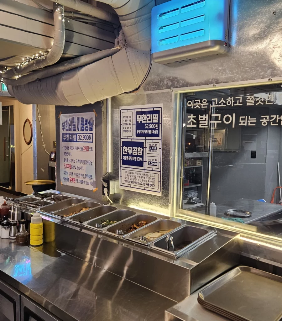 Self-service side dish bar at a Korean gopchang restaurant featuring vegetables, sauces, and accompaniments.
