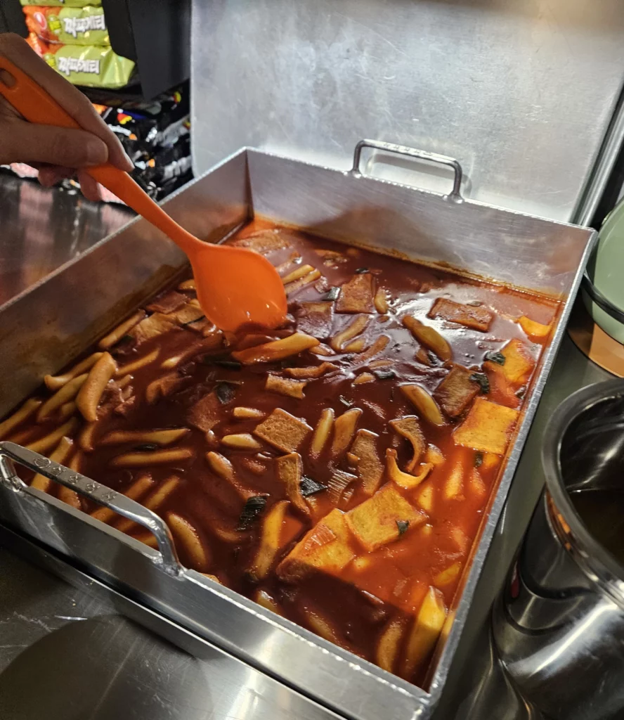 Spicy Korean tteokbokki prepared at a self-serve bar, commonly enjoyed as a side dish at a gopchang restaurant.