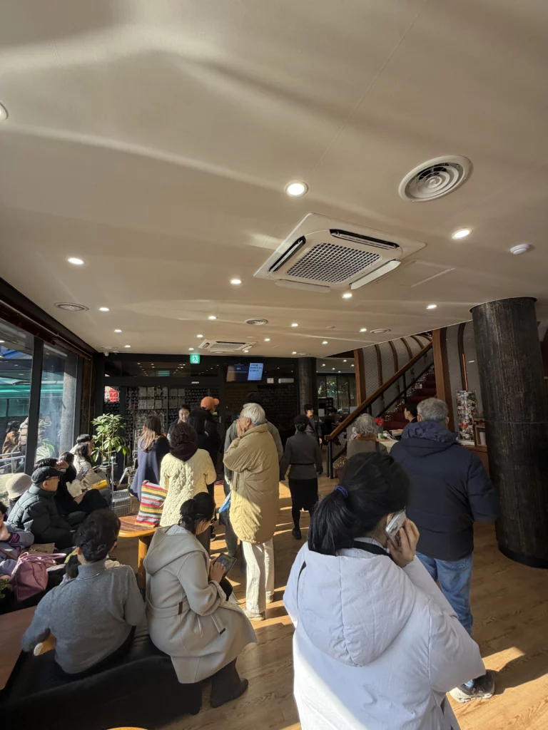 Customers waiting in line inside Woo Lae Oak Seoul during peak hours, demonstrating the popularity of this Michelin Bib Gourmand restaurant famous for authentic Pyongyang naengmyeon and premium bulgogi near Euljiro 4-ga Station.