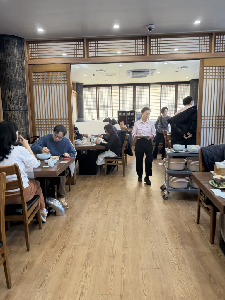 Traditional dining room at Woo Lae Oak Seoul featuring Korean lattice wooden partitions, wooden tables where guests enjoy authentic Pyongyang naengmyeon and bulgogi in the Michelin Bib Gourmand restaurant's warm interior setting.