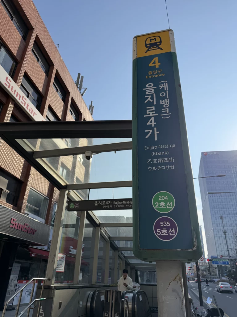 Euljiro 4-ga Station Exit 4 sign for Seoul subway Lines 2 and 5, the nearest subway station to Woo Lae Oak restaurant located approximately five minutes walking distance through Jung-gu district alleys.