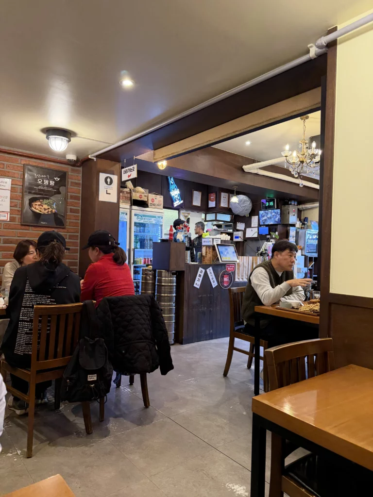Gyeyeolsa basement dining room interior with customers enjoying Korean fried chicken and beer in traditional Seoul Buam-dong restaurant atmosphere.