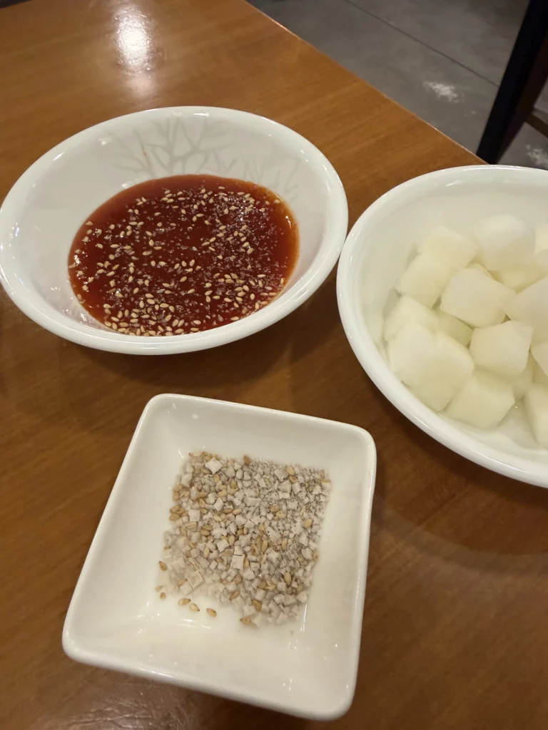 Gyeyeolsa Korean fried chicken dipping sauces and pickled radish side dishes including spicy sesame sauce at Seoul Buam-dong restaurant.