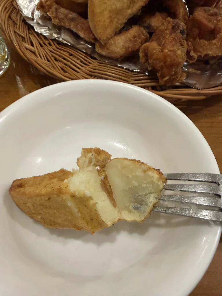 Gyeyeolsa double-fried potato wedge cross-section showing fluffy interior with crispy batter coating at Seoul Buam-dong fried chicken restaurant.