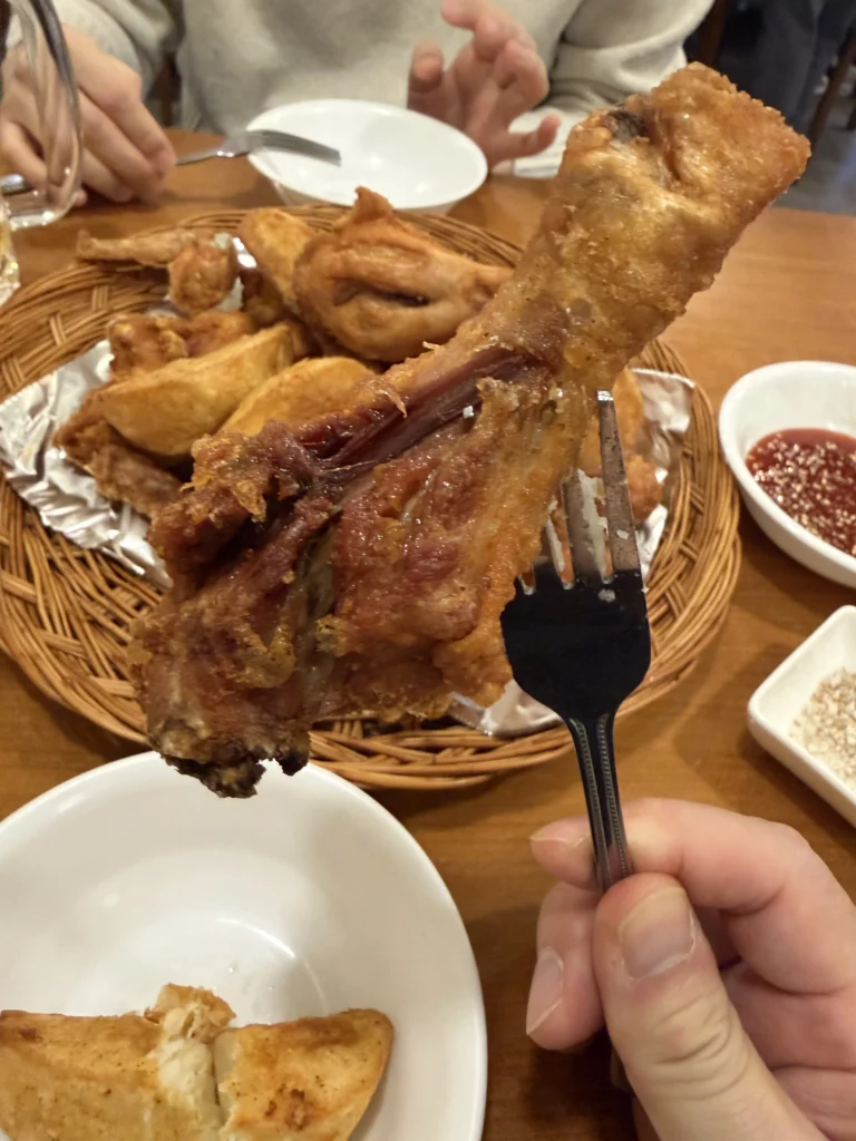 Crispy Korean fried chicken being enjoyed at Gyeyeolsa restaurant in Seoul Buam-dong showing signature thin batter coating.