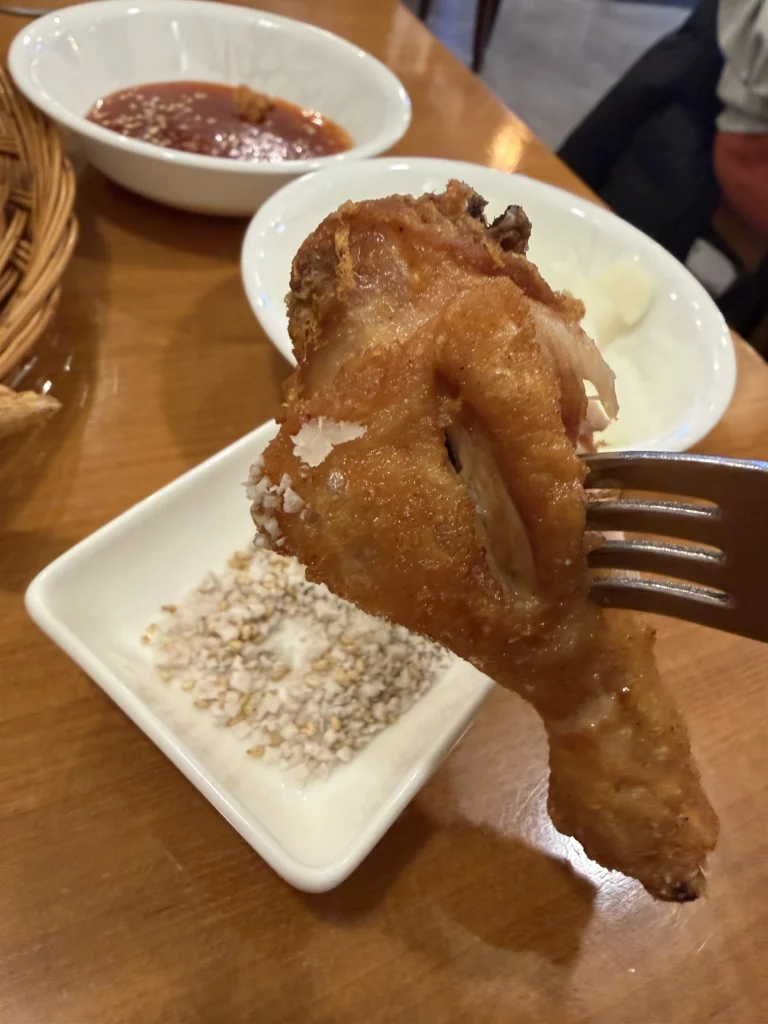 Gyeyeolsa crispy Korean fried chicken with glutinous rice flour batter served with crushed peanut garnish and spicy sauce at Seoul Buam-dong restaurant.