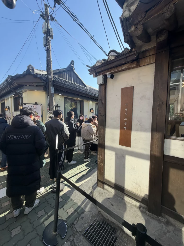 Customers waiting in line outside Jayeondo Salt Bread bakery in traditional hanok building at Ikseon-dong Seoul.