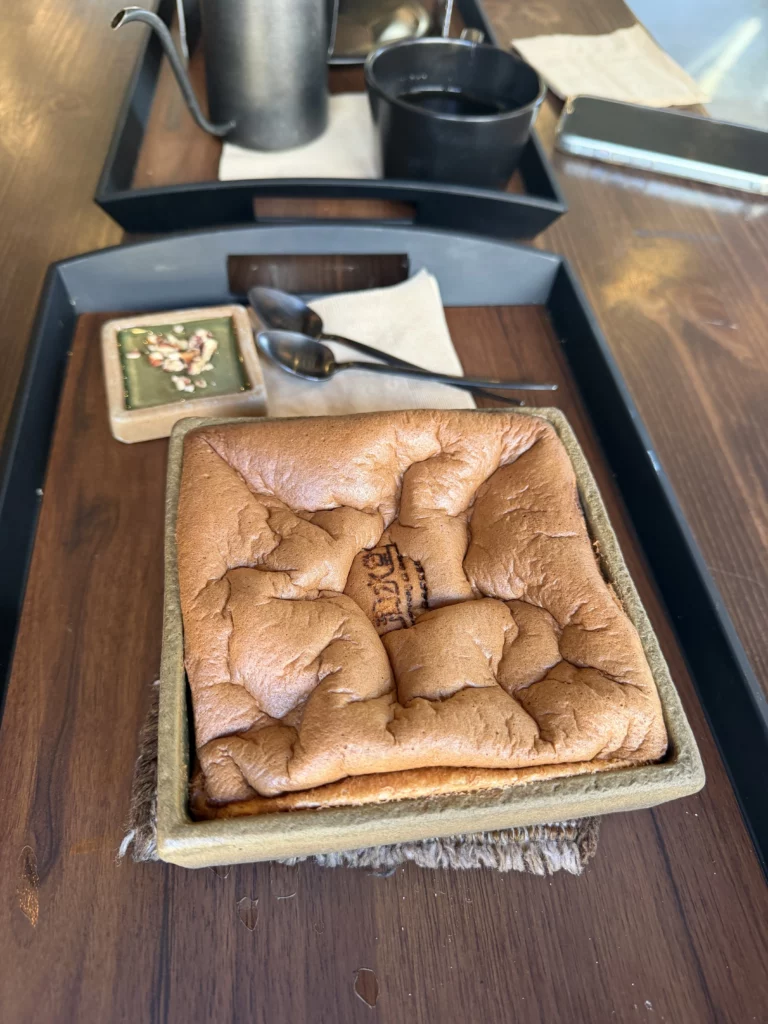 Freshly baked souffle castella served in traditional pottery dish at Cheongsu-dang Bakery Seoul, featuring the signature jiggly texture and golden-brown surface of this popular Ikseon-dong hanok cafe dessert.