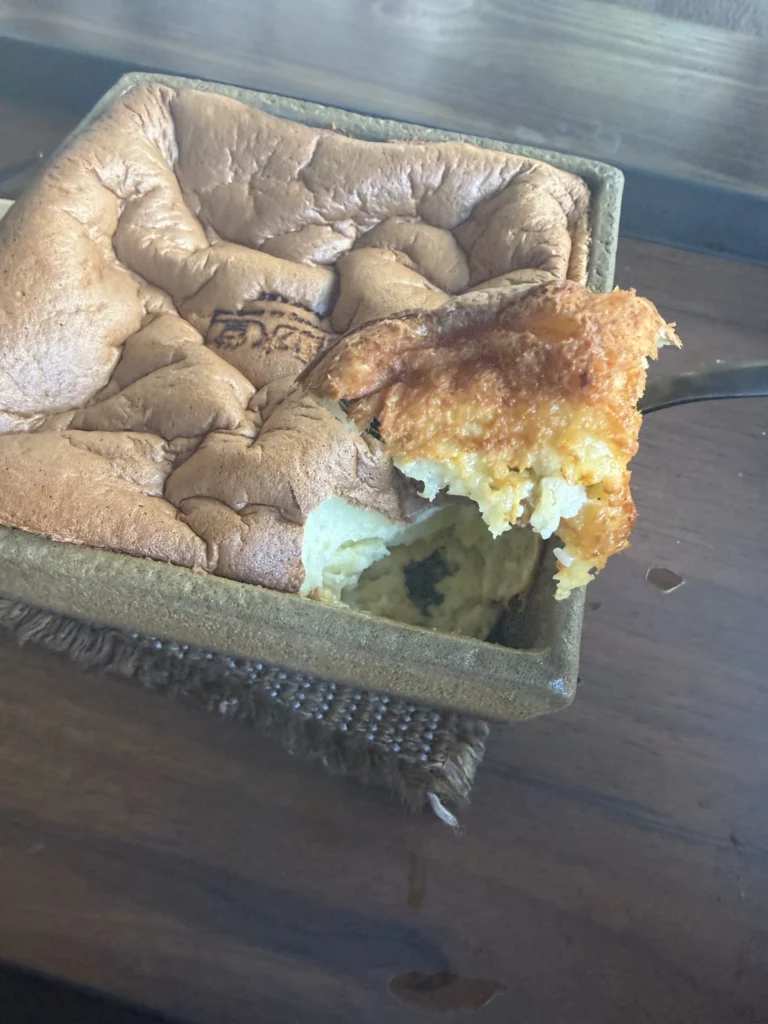 Sliced souffle castella revealing light fluffy interior texture at Cheongsu-dang Bakery in Seoul Ikseon-dong, showcasing the signature jiggly cake's airy structure served in traditional Korean pottery.