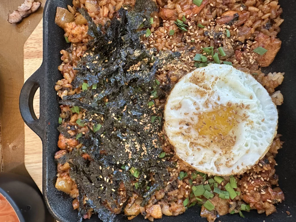 Bokkeumbap stir-fried rice topped with fried egg and roasted seaweed made from charcoal grilled chicken galbi sauce at Tongnamujip.